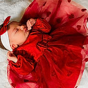 élyna a rejoint le concours — aidez-le/la à gagner de superbes lots ! baby, infant, sleeping, red_dress, headband, bow, white_blanket, glitter, hearts, soft_texture, cute, peaceful, child, newborn, portrait, clothing, resting, indoor, toddler, adorable