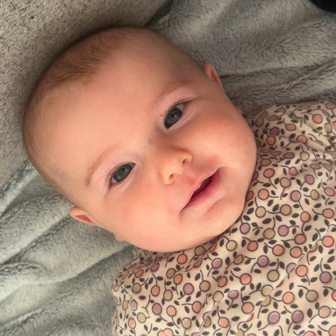 Lyncé a rejoint le concours — aidez-le/la à gagner de superbes lots ! baby, blanket, child, clothing, cozy, cute, eyes, face, happy, head, indoors, infant, lying_down, patterned_onesie, person, portrait, skin, smile, soft_texture, young