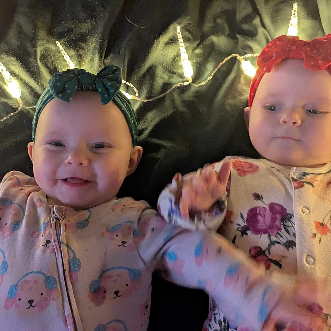 Mavis And Nora is registered to the contest to win money with this photo: accessories, baby, bodypart, bonnet, cap, clothing, costume, couch, face, finger, furniture, hand, hat, head, headband, jewelry, necklace, person, photography, portrait