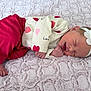 baby, newborn, infant, sleeping, headband, flower_headband, blanket, pink, onesie, pants, toes, hand, face, cozy, soft_texture, bedding, heart_pattern, portrait, peaceful, cute