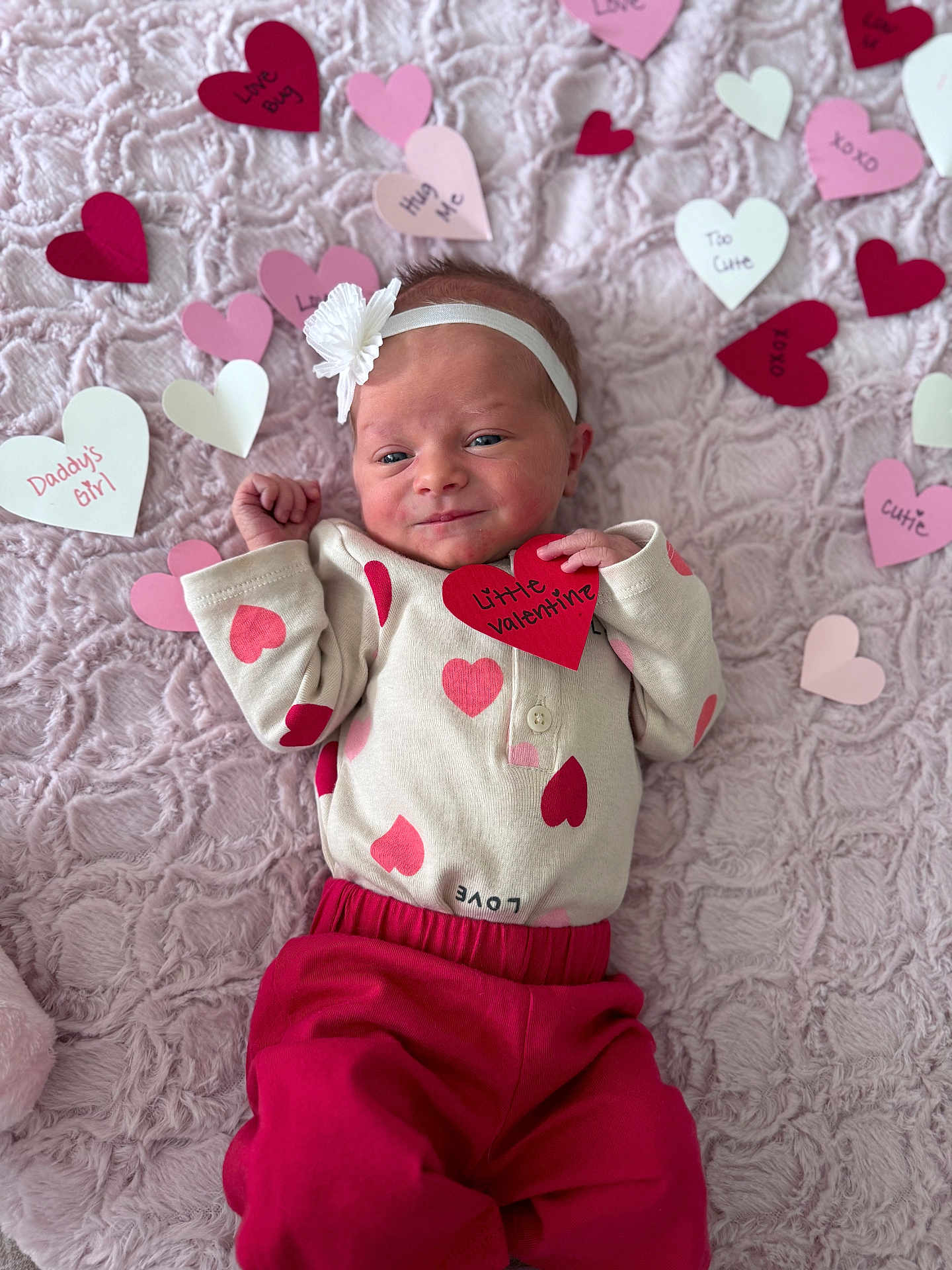 Birdie is registered to the contest to win money with this photo: baby, infant, newborn, heart, valentine, blanket, headband, pink, red, onesie, pants, smile, hand, portrait, cozy, paper_hearts, soft_texture, cute, fabric, decor