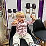 Gabriel a rejoint le concours — aidez-le/la à gagner de superbes lots ! toddler, child, smiling, indoor, shopping, store, chair, black_chair, clothing, sneakers, pink_shirt, white_pants, wooden_pallet, barstool_box, floor, aisle, person, happy, casual, retail
