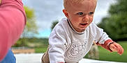 Gabriel participe au concours pour gagner de l'argent avec cette photo : toddler, child, blonde_hair, blue_eyes, crawling, white_sweater, outdoor, greenery, cloudy_sky, person, pink_sleeve, hand, face, curious, young_child, playful, soft_focus, daylight, nature, casual_clothing