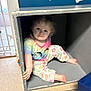 Rosie joined the competition — help win amazing prizes! toddler, child, cubicle, colorful_clothing, tie_dye_shirt, floral_pants, barefoot, indoor, floor_mat, blue_wall, curious_expression, small_space, play_area, cubbyhole, person, young_child, sitting, cute, home, playful