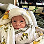 Cayson is registered to the contest to win money with this photo: baby, blanket, clothing, cozy, curious, cute, face, giraffe_pattern, head_covered, indoor, infant, newborn, person, portrait, resting, soft_texture, warm, wide_eyes, wrapped, young_child