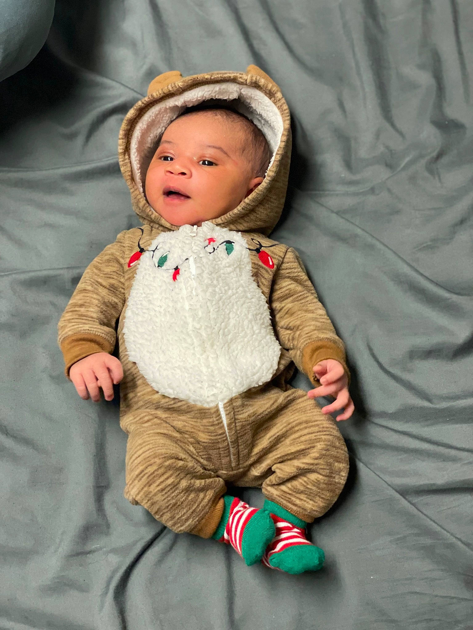 Braylen is registered to the contest to win money with this photo: baby, baby_toddler_clothing, cheek, child, chin, clothing, comfort, face, fun, linens, nose, pattern, person, room, sitting, skin, sleeve, smile, toddler, wood