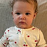 toddler, child, onesie, cherry_pattern, earrings, sitting, blanket, indoor, cute, portrait, face, hair, clothing, young_child, baby, expression, person, infant, cozy, casual