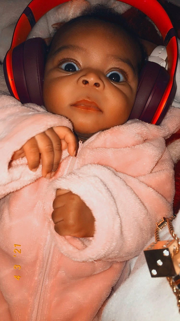 Zaniyah is registered to the contest to win money with this photo: baby, baby_toddler_clothing, cheek, comfort, finger, gesture, happy, human_body, iris, lip, mouth, nose, orange, person, pink, product, skin, sleeve, smile, toddler