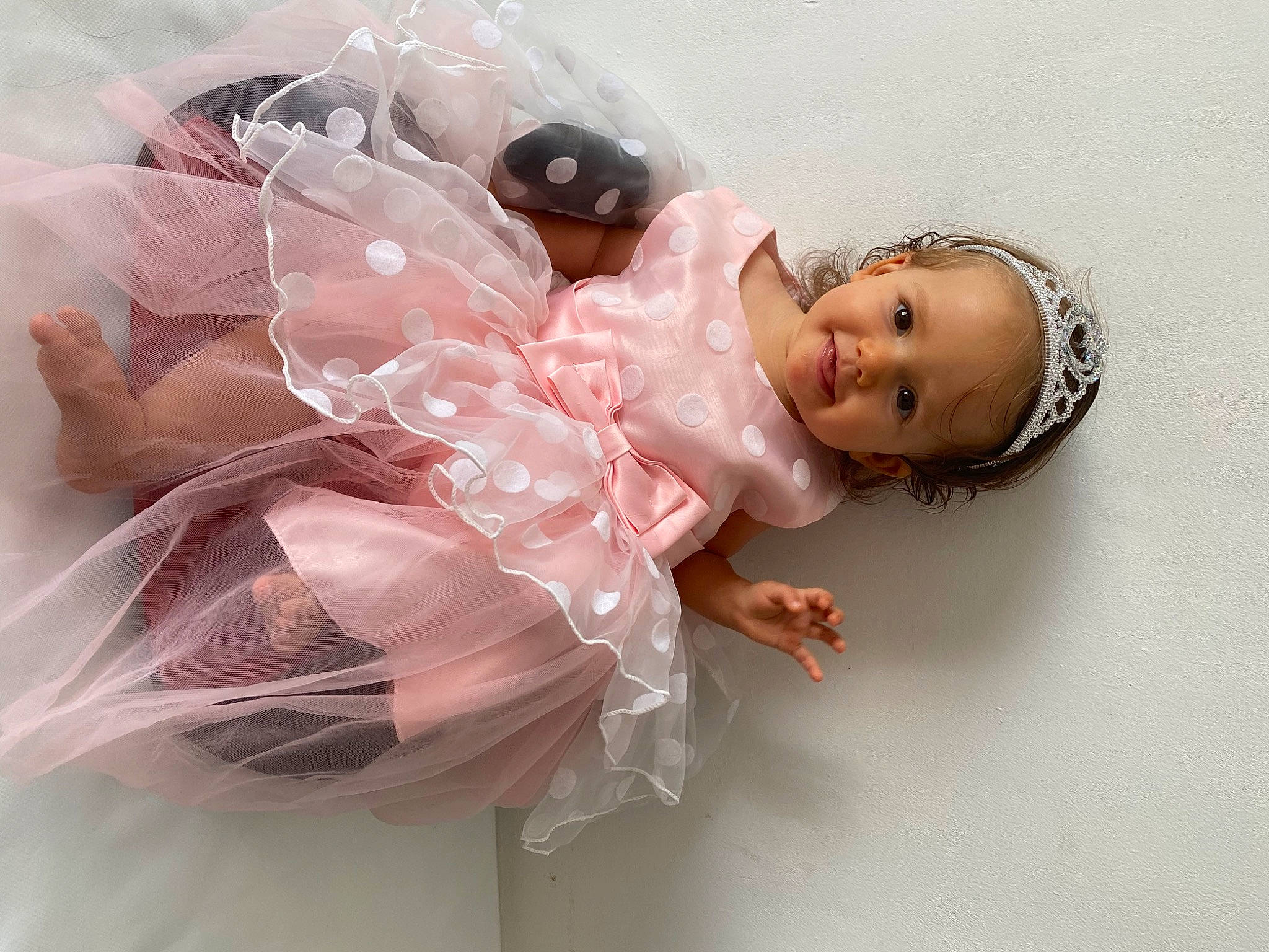 Cinthia participe au concours pour gagner de l'argent avec cette photo : baby_toddler_clothing, bridal_accessory, child, day_dress, dress, embellishment, eye, eyelash, fashion_accessory, hair_accessory, happy, head, headgear, headpiece, jewellery, joy, mythical_creature, person, pink, skin