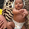 baby, diaper, hand, blanket, pattern, skin, infant, cute, lying_down, child, nail_polish, person, fingers, legs, torso, soft_texture, comfort, indoors, relaxed, closeup