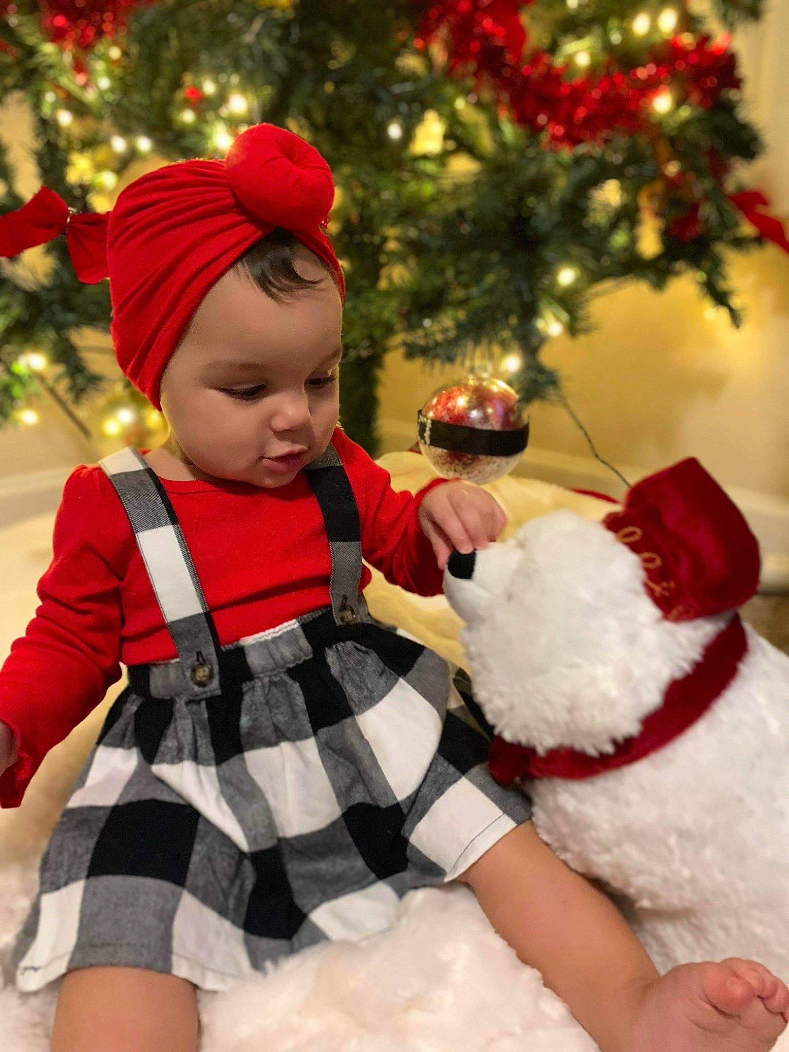Maliyah is registered to the contest to win money with this photo: baby, baby_toddler_clothing, christmas_decoration, christmas_ornament, christmas_tree, event, facial_expression, happy, hat, head, human_body, lap, ornament, outerwear, person, photograph, plant, santa_claus, toddler, tree