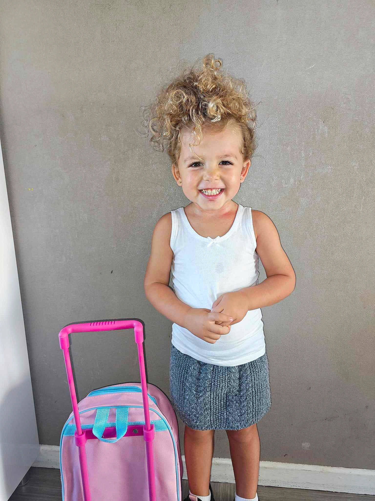 Taïssya a rejoint le concours — aidez-le/la à gagner de superbes lots ! baby_toddler_clothing, bag, child, cleanliness, fun, happy, human_leg, joy, knee, luggage_and_bags, magenta, pattern, person, pink, room, shorts, sitting, sleeve, smile, t_shirt