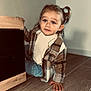 Julia a rejoint le concours — aidez-le/la à gagner de superbes lots ! candid, casual_clothing, child, curious, cute, floor, hair_tied, hand, indoor, jeans, light, person, plaid_jacket, portrait, shadow, tile_floor, toddler, wall, wooden_cabinet, young