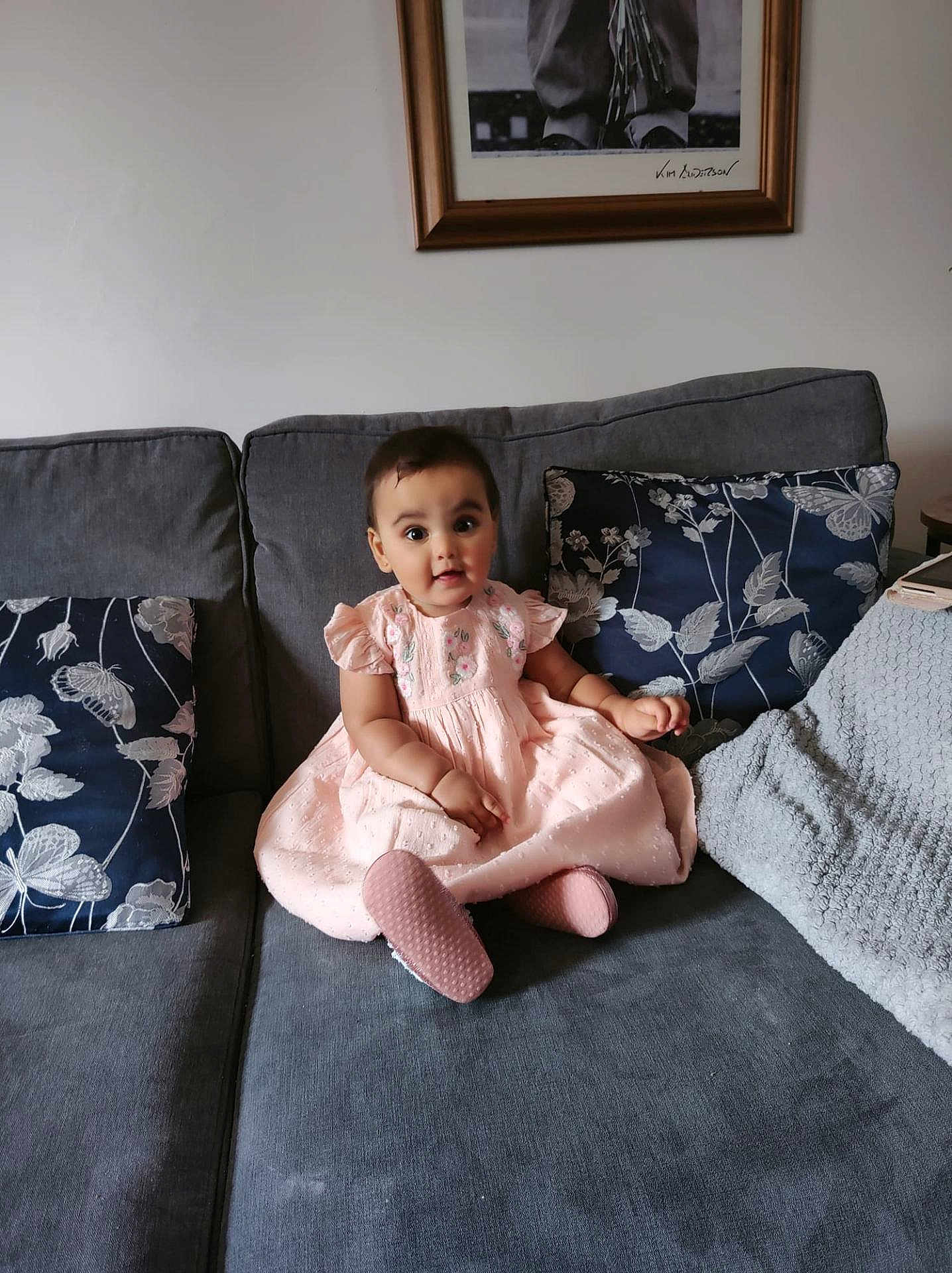 Aaliyah joined the competition — help win amazing prizes! baby, child, pink_dress, couch, sofa, cushion, blanket, indoor, portrait, smiling, face, person, seated, home, decor, furniture, photography, young_child, happy, cute