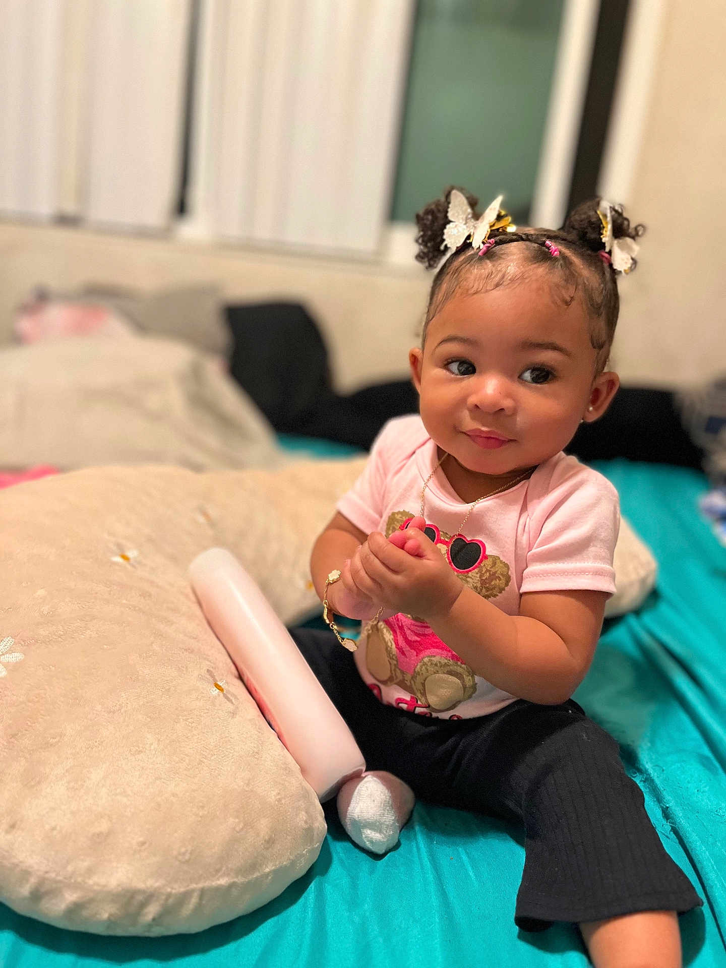 Dream joined the competition — help win amazing prizes! toddler, child, baby, indoor, bed, pillow, pink_shirt, black_pants, bracelet, necklace, hair_accessories, butterfly, curly_hair, sitting, holding_object, cute, portrait, person, cozy, soft_lighting