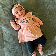 Kalia joined the competition — help win amazing prizes! baby, infant, smile, pink_clothing, headband, socks, blanket, soft_texture, lying_down, happy, cute, child, face, indoors, portrait, apparel, person, young, cozy, resting