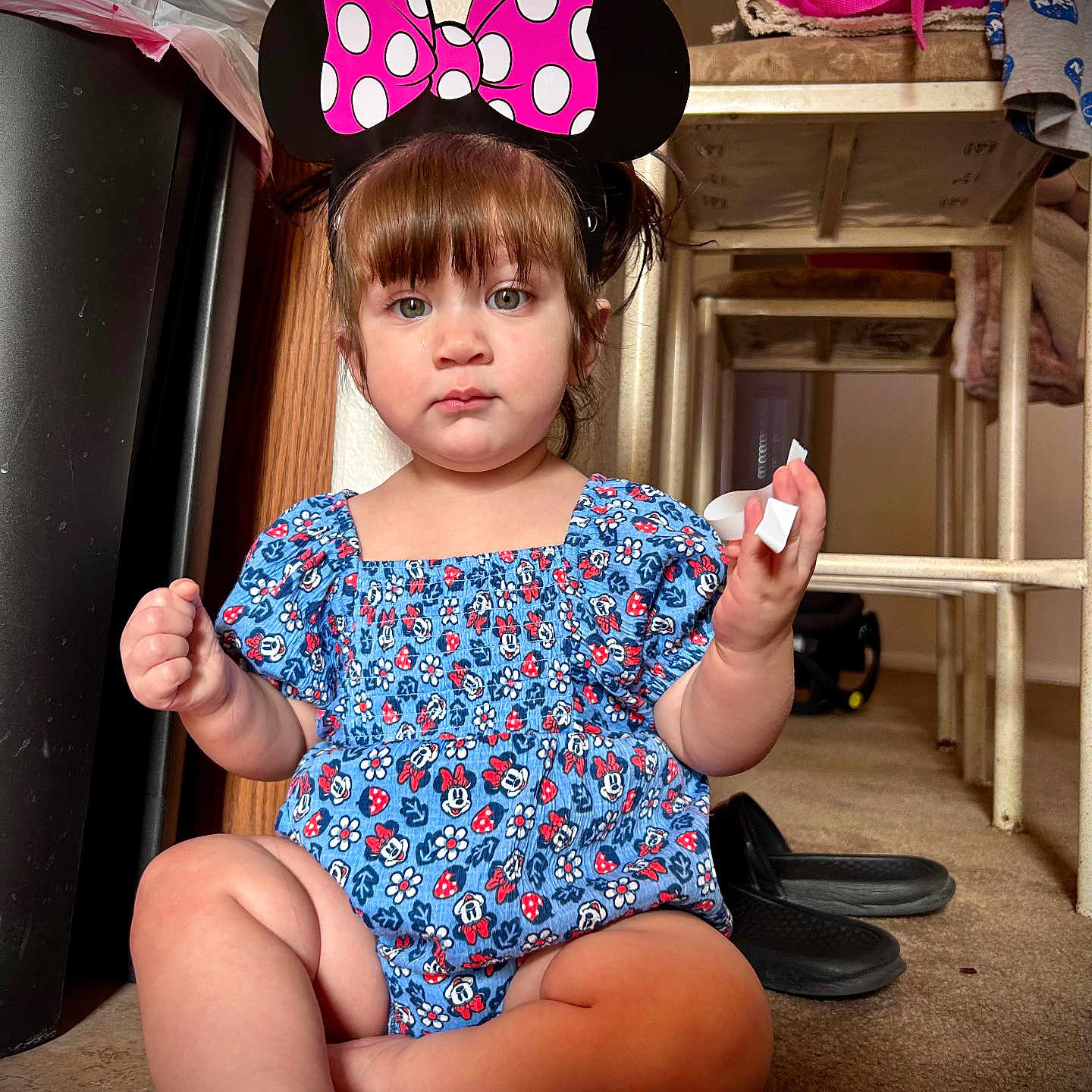 Liliana is registered to the contest to win money with this photo: baby, bodypart, clothing, costume, dress, face, finger, footwear, furniture, hand, hardwood, hat, head, indoors, person, photography, portrait, sitting, t_shirt, wood
