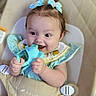 Ivy is registered to the contest to win money with this photo: baby, child, blue_bow, toy, smile, happy, cute, infant, seat, baby_seat, clothing, polka_dot, hands, face, hair, indoor, playful, young_child, portrait, delight
