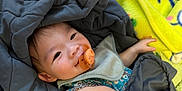 Aiden joined the competition — help win amazing prizes! baby, pacifier, blanket, quilt, bib, smile, child, infant, face, clothing, hand, yellow, blue, cute, cozy, resting, indoors, soft, comfort, portrait