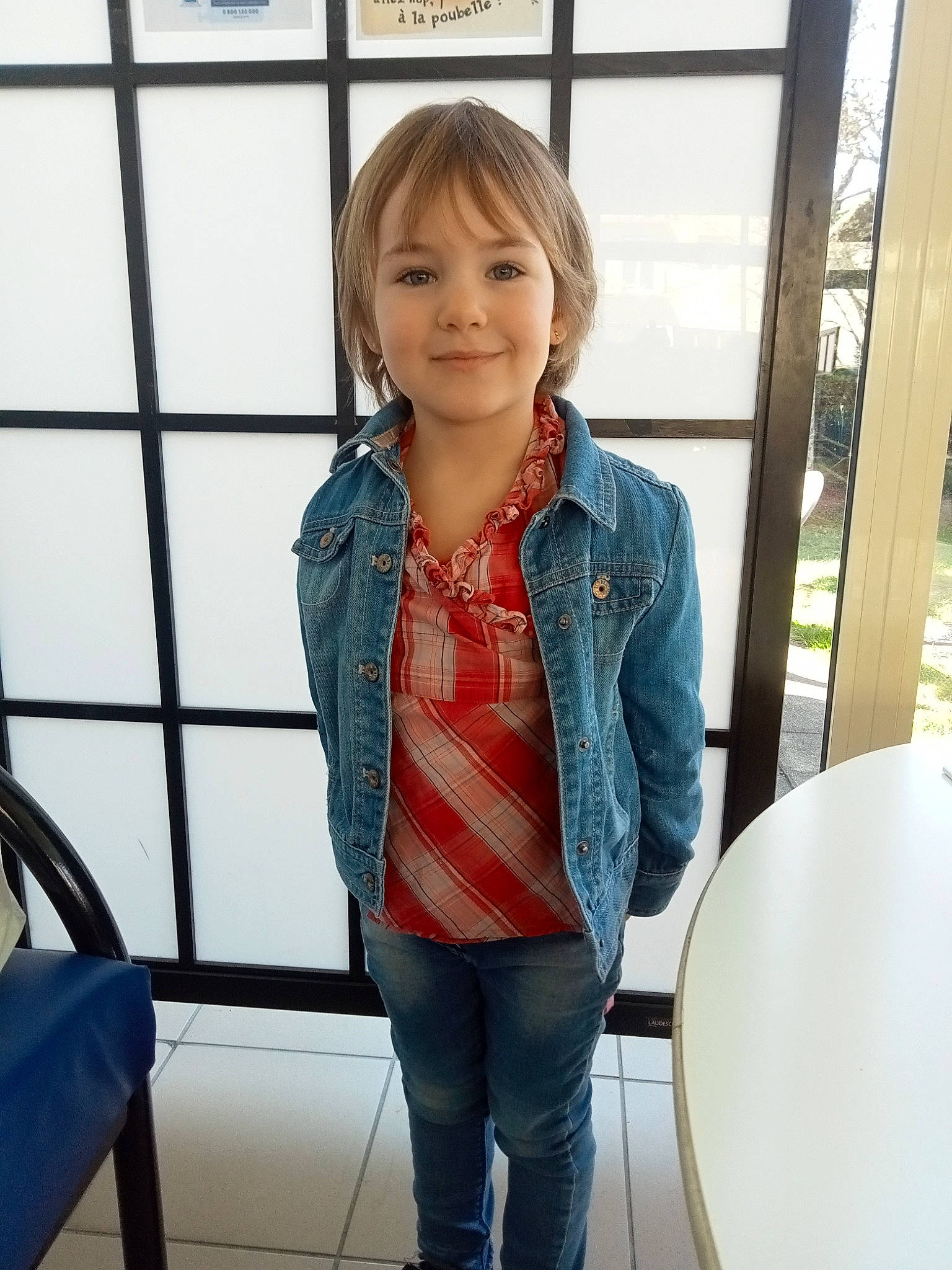 Elena participe au concours pour gagner de l'argent avec cette photo : blazer, collar, denim, dress_shirt, electric_blue, fun, happy, jeans, joy, knee, pattern, person, room, shoulder, sitting, sleeve, smile, toddler, travel, uniform