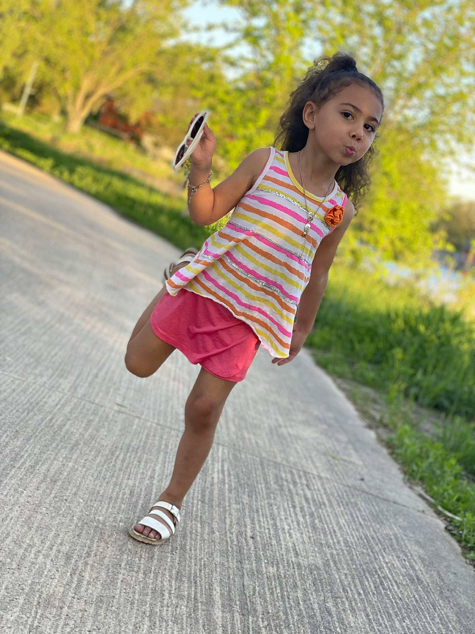 Avah Jean is registered to the contest to win money with this photo: asphalt, dress, electric_blue, fun, grass, happy, human_leg, knee, leisure, magenta, pattern, person, plant, recreation, sleeve, sportswear, t_shirt, thigh, toddler, tree