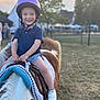 Côme participe au concours pour gagner de l'argent avec cette photo : child, toddler, helmet, pony, horse, riding, smile, outdoor, grass, sunset, blue_shirt, shorts, white_shoes, happy, animal, saddle, park, daylight, portrait, fun