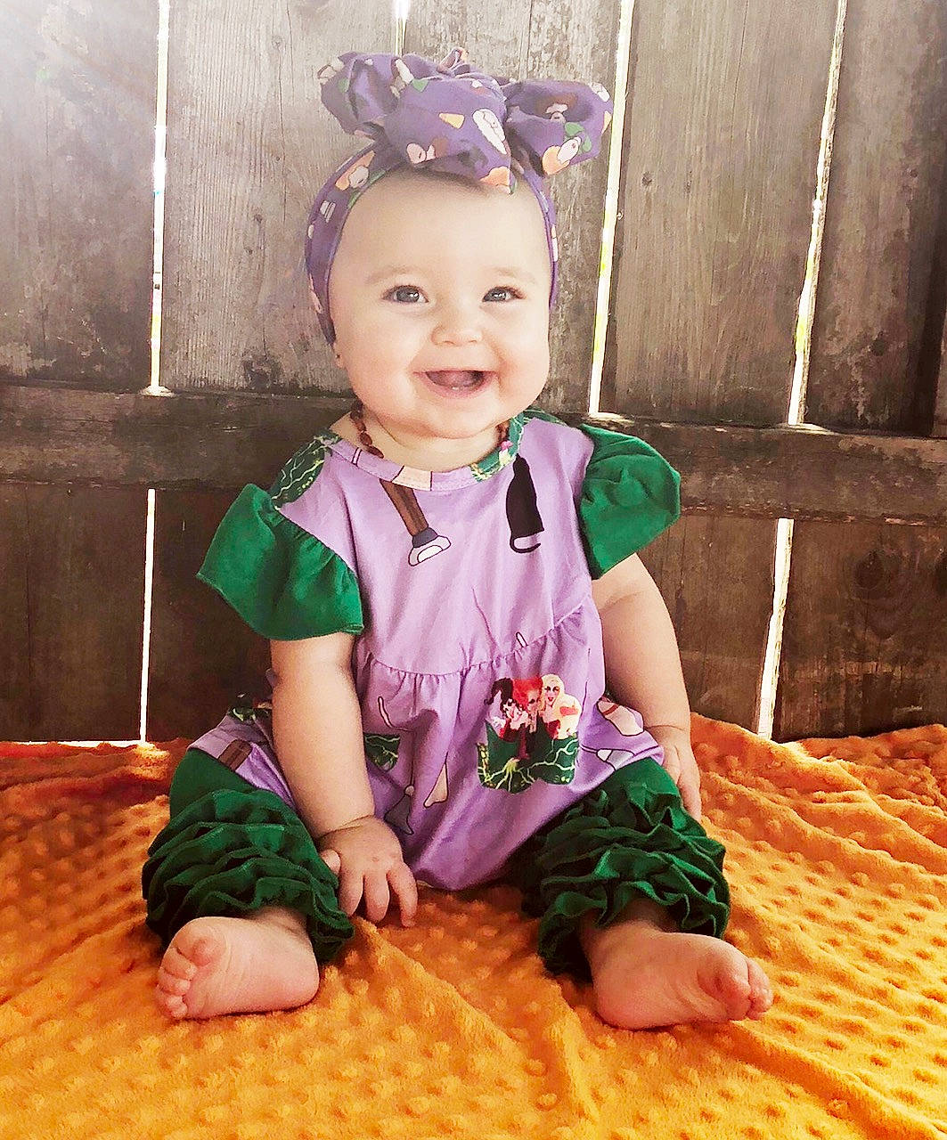 Huntley is registered to the contest to win money with this photo: arm, baby, baby_toddler_clothing, cheek, child, fashion_accessory, floor, fun, hair_accessory, happy, head, headband, headgear, joy, leg, person, play, purple, sitting, skin