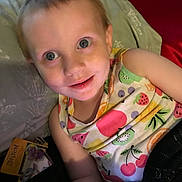 Summer is registered to the contest to win money with this photo: child, toddler, smiling, bed, pillow, blanket, colorful_clothing, fruit_pattern, smartphone, toy_package, indoor, person, face, happy, casual, young_child, relaxed, candid, portrait, blue_eyes