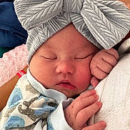 Alora is registered to the contest to win money with this photo: baby, newborn, sleeping, headband, bow, knitted, hand, face, clothing, soft, cozy, infant, peaceful, closeup, skin, cute, portrait, wrapped, rest, child