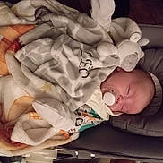 Léo participe au concours pour gagner de l'argent avec cette photo : baby, sleeping, blanket, pacifier, plush_toy, cushion, infant, cozy, soft, clothing, face, resting, indoors, child, cute, newborn, comfort, peaceful, head, lying_down