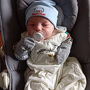 Léo a rejoint le concours — aidez-le/la à gagner de superbes lots ! baby, pacifier, hat, clothing, mittens, baby_seat, blanket, infant, face, sleepy, cute, child, indoors, comfort, soft, rest, newborn, white, gray, portrait