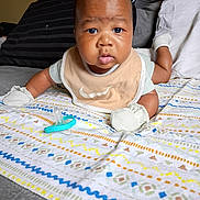 Zi'Cani joined the competition — help win amazing prizes! baby, infant, blanket, pacifier, bed, pillow, mittens, bib, face, expression, indoor, child, cute, lying_down, patterned_blanket, clothing, skin, head, eyes, mouth
