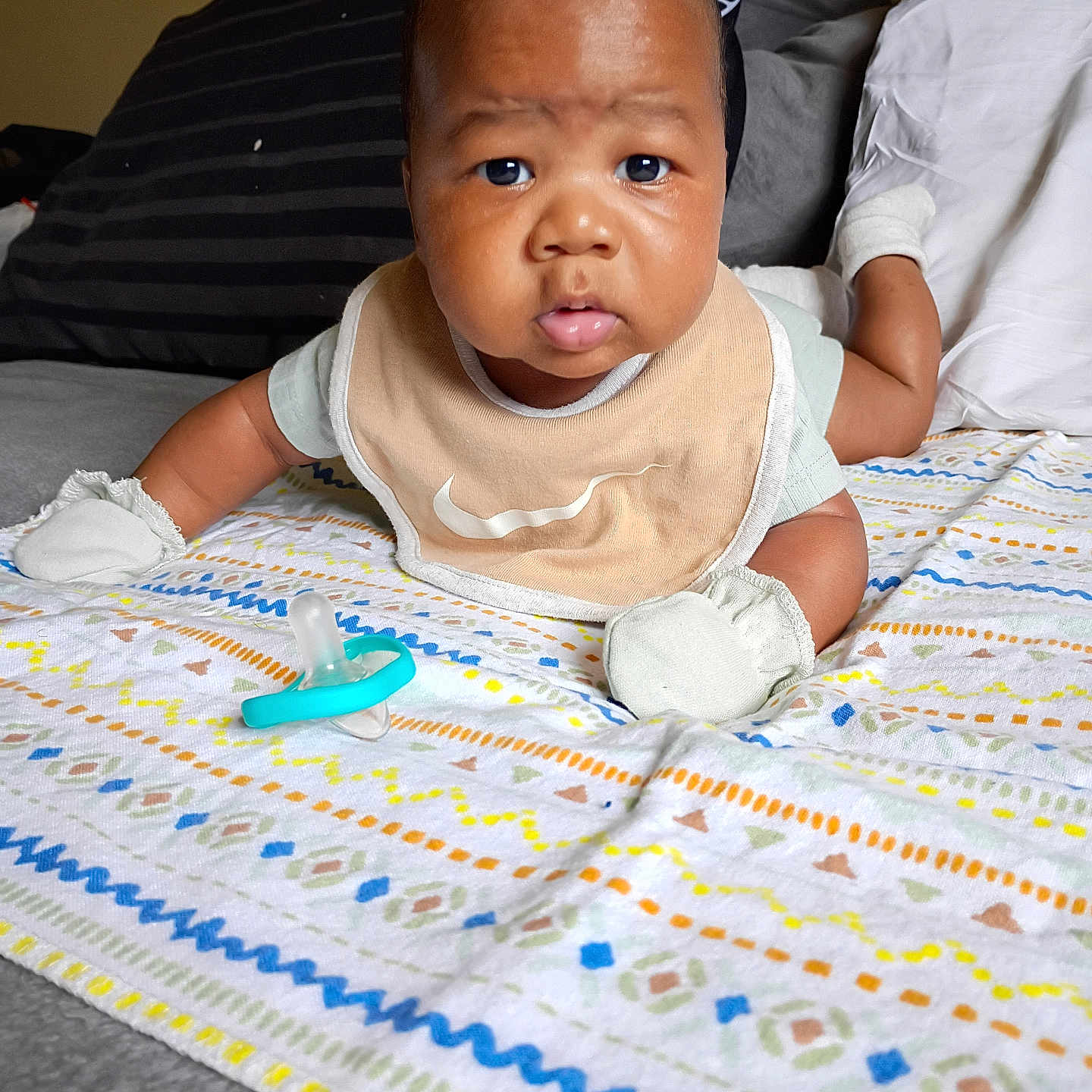 Zi'Cani joined the competition — help win amazing prizes! baby, bed, bib, blanket, child, clothing, cute, expression, eyes, face, head, indoor, infant, lying_down, mittens, mouth, pacifier, patterned_blanket, pillow, skin