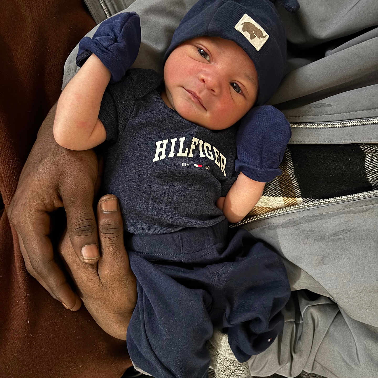 Jameon joined the competition — help win amazing prizes! adult_hand, baby, blanket, child, closeup, clothing, couch, cozy, hands, hat, indoor, infant, knit_cap, mittens, newborn, onesie, person, portrait, reclining, socks