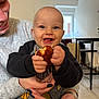 Ayden participe au concours pour gagner de l'argent avec cette photo : baby, child, smile, food, hands, adult, sweater, nails, indoor, window, table, chair, face, happy, crumbs, clothing, person, holding, joy, casual