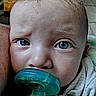 Amara is registered to the contest to win money with this photo: baby, blanket, blue_eyes, child, closeup, curly_hair, cute, expression, eyelashes, face, head, indoors, infant, mouth, nose, pacifier, person, skin, soft_lighting, young