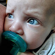 Amara is registered to the contest to win money with this photo: baby, blue_eyes, child, close_up, cute, detail, emotion, expression, face, hand, human, indoors, infant, looking, newborn, pacifier, portrait, skin, soft_light, young