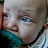 Amara is registered to the contest to win money with this photo: baby, blue_eyes, child, close_up, clothing, cute, expression, face, hand, head, human, infant, looking_away, mouth, pacifier, portrait, resting, skin, soft_lighting, young