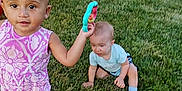 Deja is registered to the contest to win money with this photo: toddler, child, grass, outdoor, toy, pink_clothing, romper, baby, fence, garden, greenery, sitting, playing, summer, shoes, curious, cute, person, daylight, yard