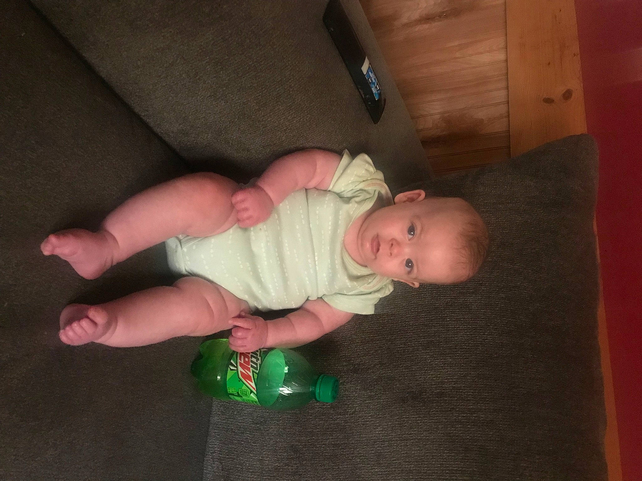 Claire is registered to the contest to win money with this photo: baby, baby_products, baby_toddler_clothing, cheek, child, comfort, finger, floor, flooring, foot, fun, grass, hardwood, human_leg, person, room, sitting, sock, thumb, toddler