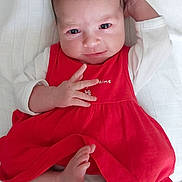 Victoria participe au concours pour gagner de l'argent avec cette photo : baby, infant, red_dress, white_sleeves, blanket, foot, hand, face, eyes, skin, newborn, lying_down, cute, child, portrait, indoors, expression, relaxed, young, person