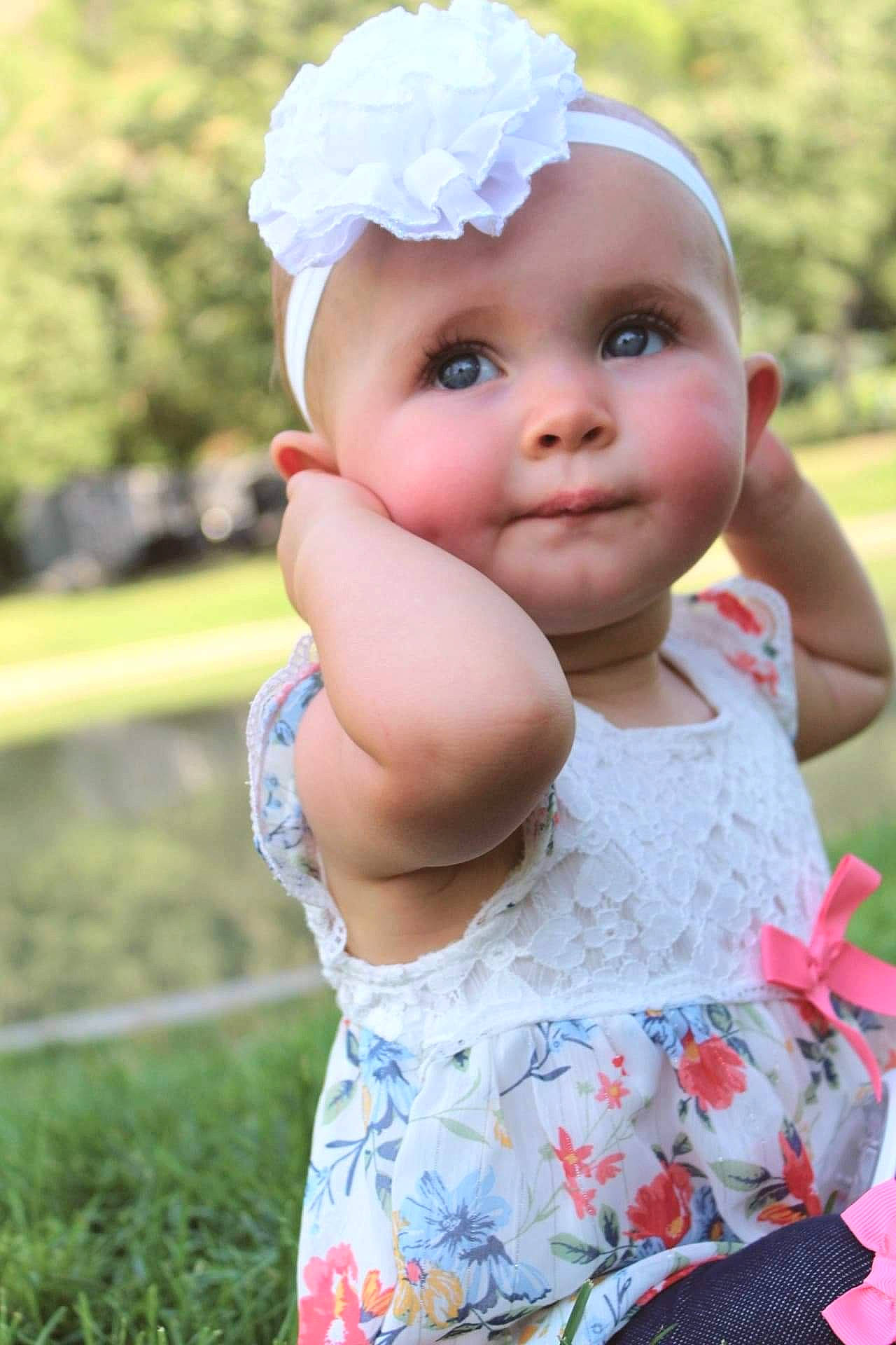 Londynn is registered to the contest to win money with this photo: baby, baby_toddler_clothing, clothing, dress, eye, face, grass, hand, happy, hat, head, headwear, iris, leaf, lip, person, pink, plant, skin, summer