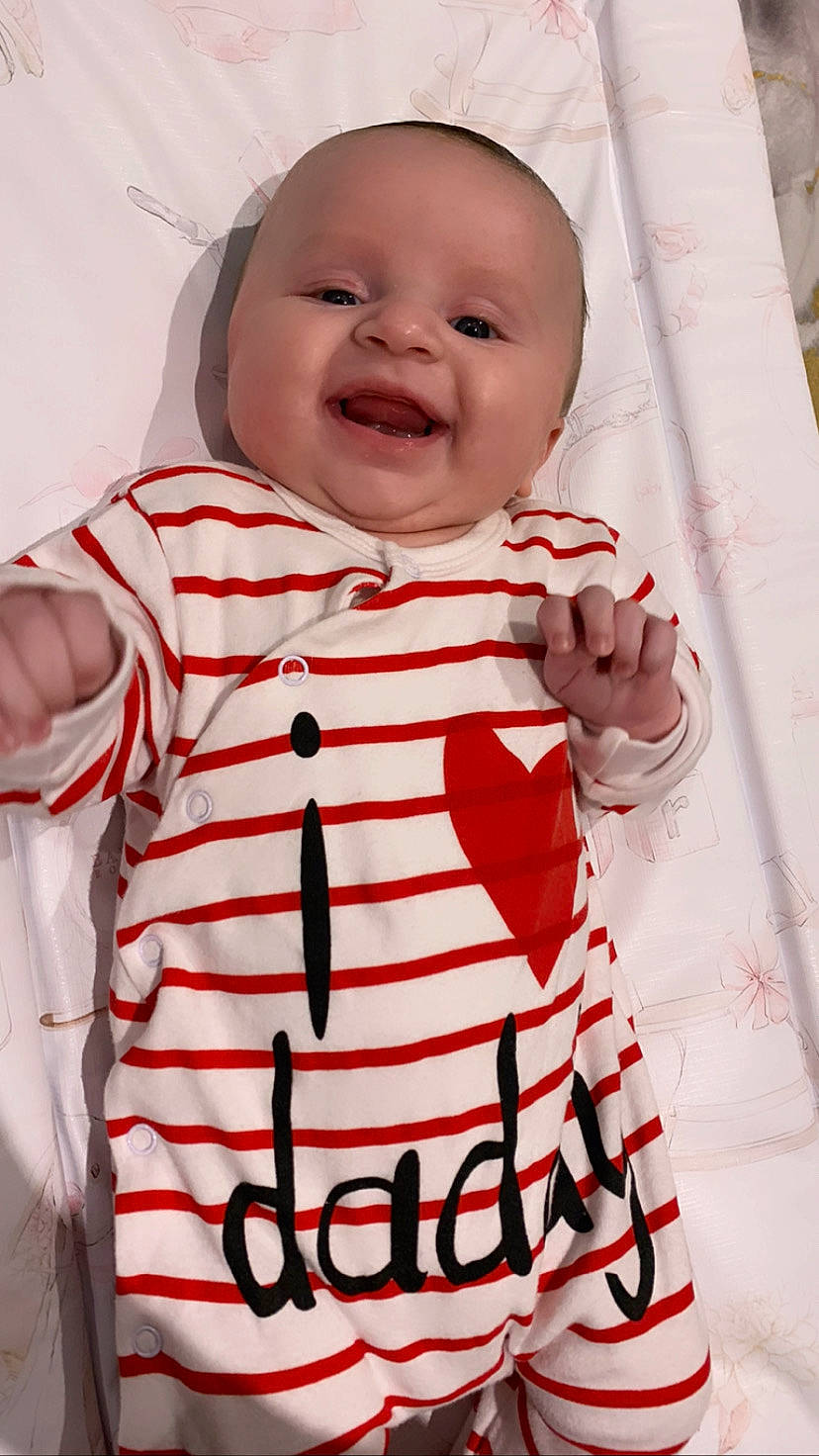 Esmé is registered to the contest to win money with this photo: arm, baby, baby_toddler_clothing, cheek, clothing, dress, face, finger, happy, head, neck, outerwear, pattern, person, pink, skin, sleeve, smile, t_shirt, toddler