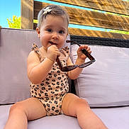 Charlie a rejoint le concours — aidez-le/la à gagner de superbes lots ! toddler, child, sunglasses, outdoor, sofa, cushion, wooden_fence, blue_sky, summer, cute, playful, infant, clothing, leopard_print, hair_clip, barefoot, smiling, sunlight, relaxing, portrait