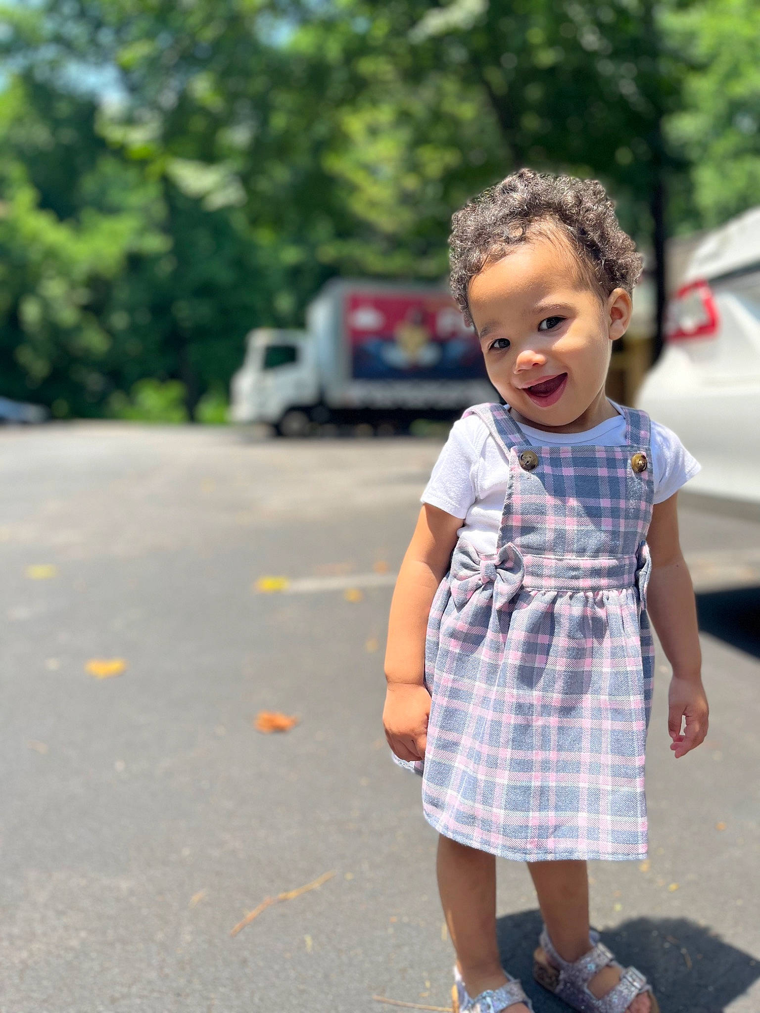 Ava joined the competition — help win amazing prizes! asphalt, blond, car, dress, electric_blue, grass, happy, leisure, pattern, person, plaid, plant, public_space, recreation, road, road_surface, smile, summer, tartan, toddler