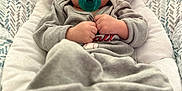 Carter is registered to the contest to win money with this photo: baby, baby_seat, child, closeup, comfort, cozy, cushion, cute, expression, feet, focus, gray_clothing, indoor, infant, pacifier, portrait, resting, small_hands, soft_texture, wide_eyes