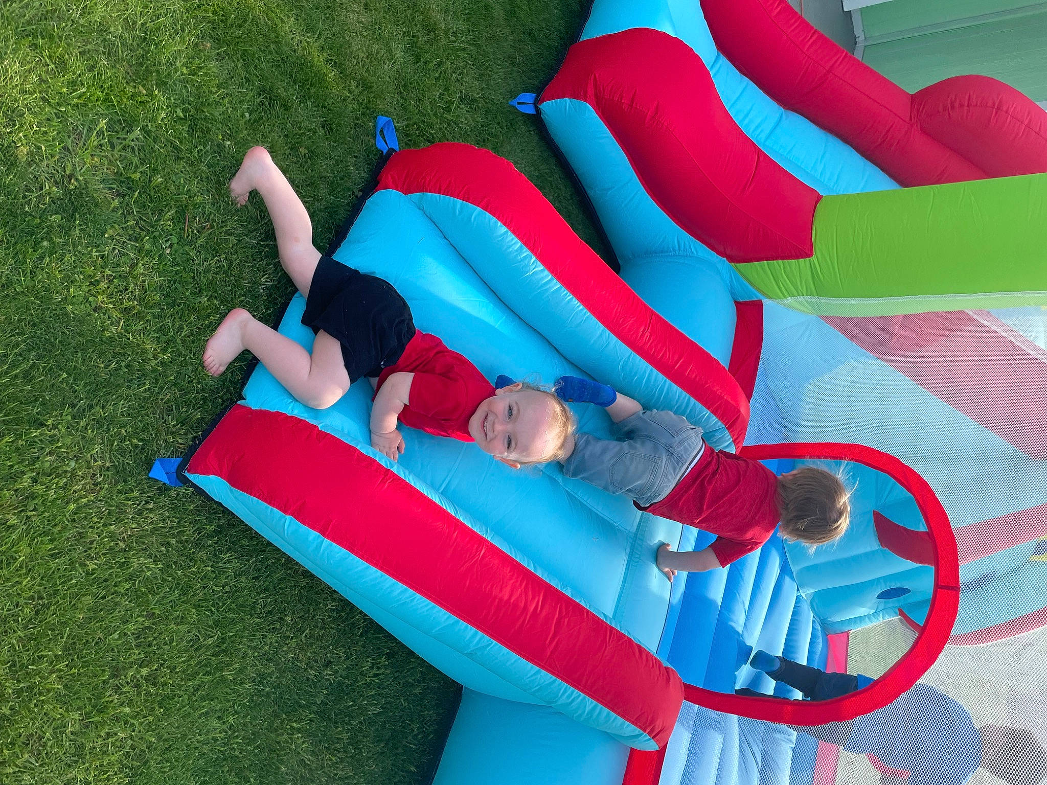 Kyson joined the competition — help win amazing prizes! azure, blue, chute, comfort, electric_blue, fictional_character, fun, grass, green, human_leg, inflatable, joy, knee, leisure, magenta, outdoor_play_equipment, person, play, recreation, red