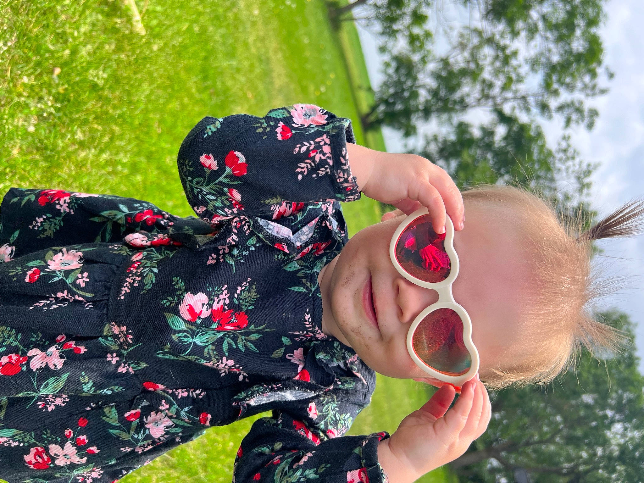 Aspen is registered to the contest to win money with this photo: botany, event, eyewear, fashion_accessory, finger, fun, gesture, grass, hand, happy, leaf, leisure, pattern, people_in_nature, person, plant, sky, sleeve, sunglasses, toddler