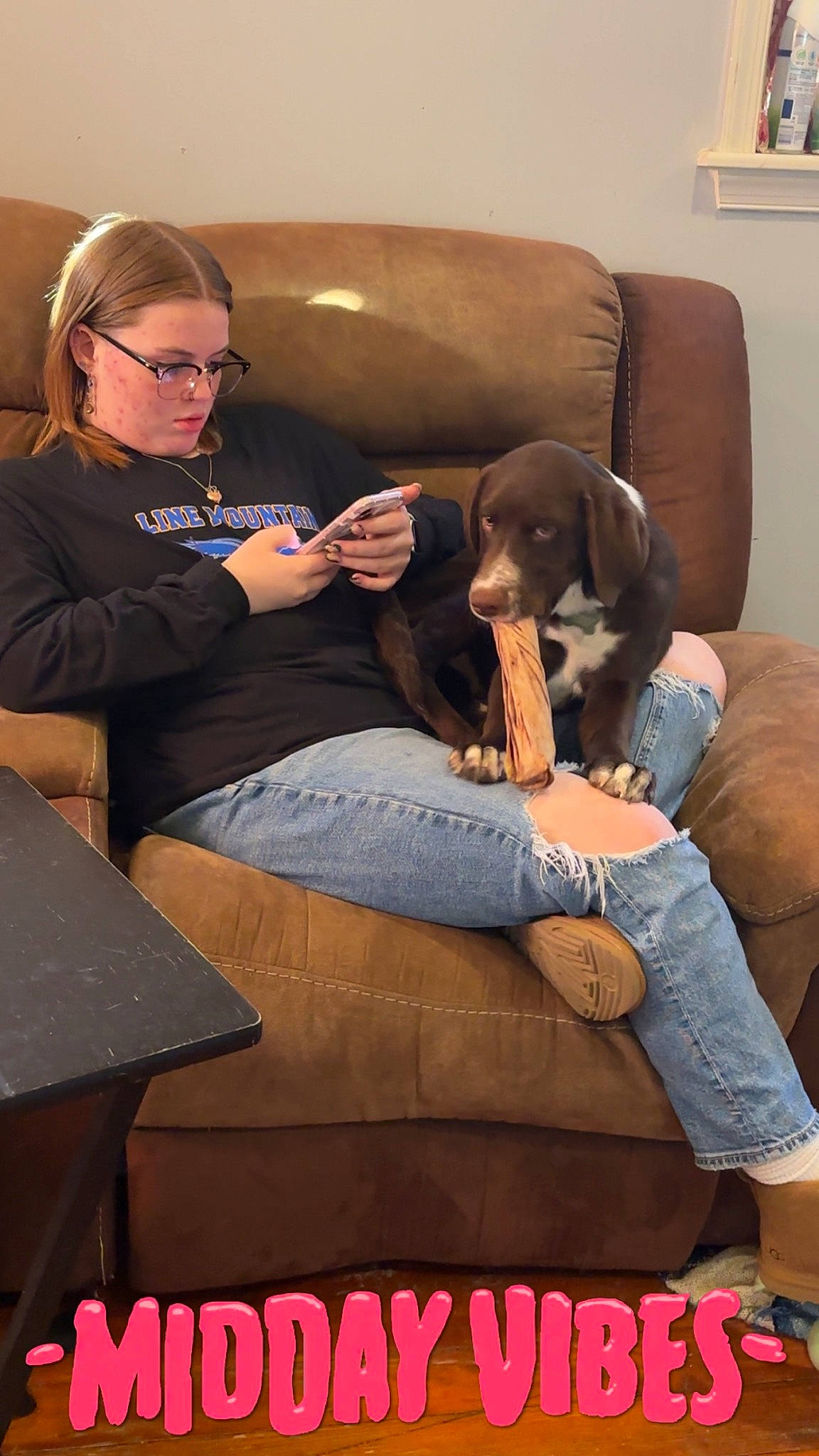 Pepsi is registered to the contest to win money with this photo: carnivore, chair, comfort, companion_dog, conversation, couch, dog, event, eyewear, flooring, glasses, human_leg, jeans, lap, leisure, living_room, sitting, sneakers, thigh, vision_care