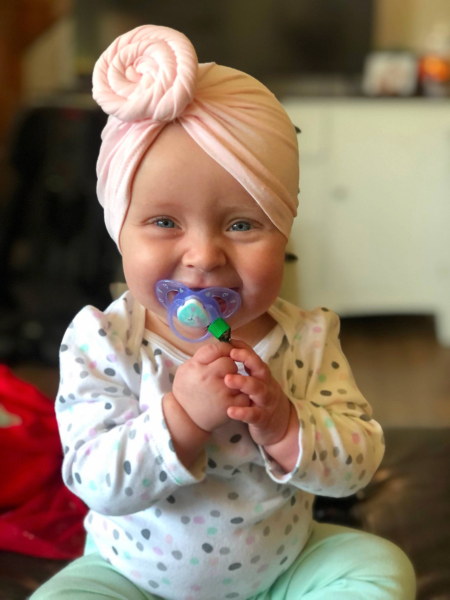 Kaylynn is registered to the contest to win money with this photo: baby, baby_grabbing_for_something, baby_toddler_clothing, child, headwear, joy, party_supply, person, polka_dot, sitting, spoon, toddler, turban